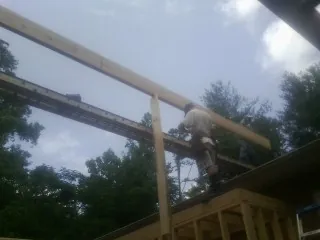 Carpenter setting a ridge beam over a new addition frame — Ice Dam Removal by Roofing Brothers in Tamworth